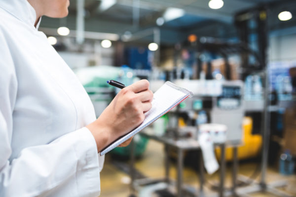Donna che controlla la produzione segnando appunti